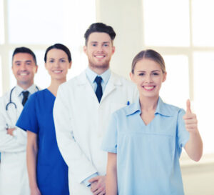 Happy Doctors Showing Thumbs Up At Hospital